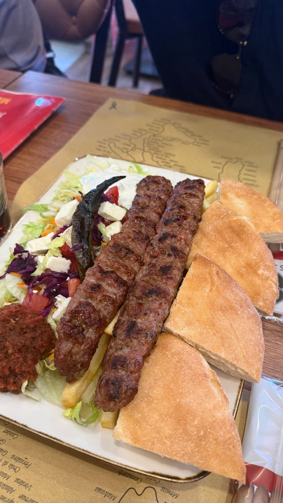 A grilled kebab platter with pita and salad at Baba Turkish in Bologna