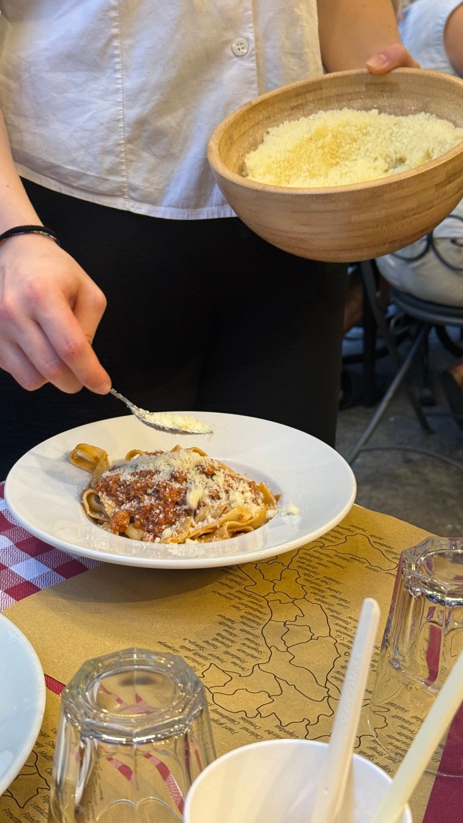A plate of tagliatelle al ragu with parmesan grated tableside at Mattarello in Bologna