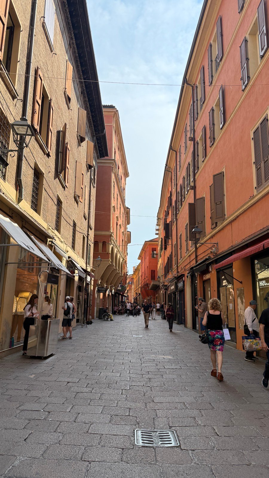A narrow shop-lined street in the Quadrilatero market quarter of Bologna