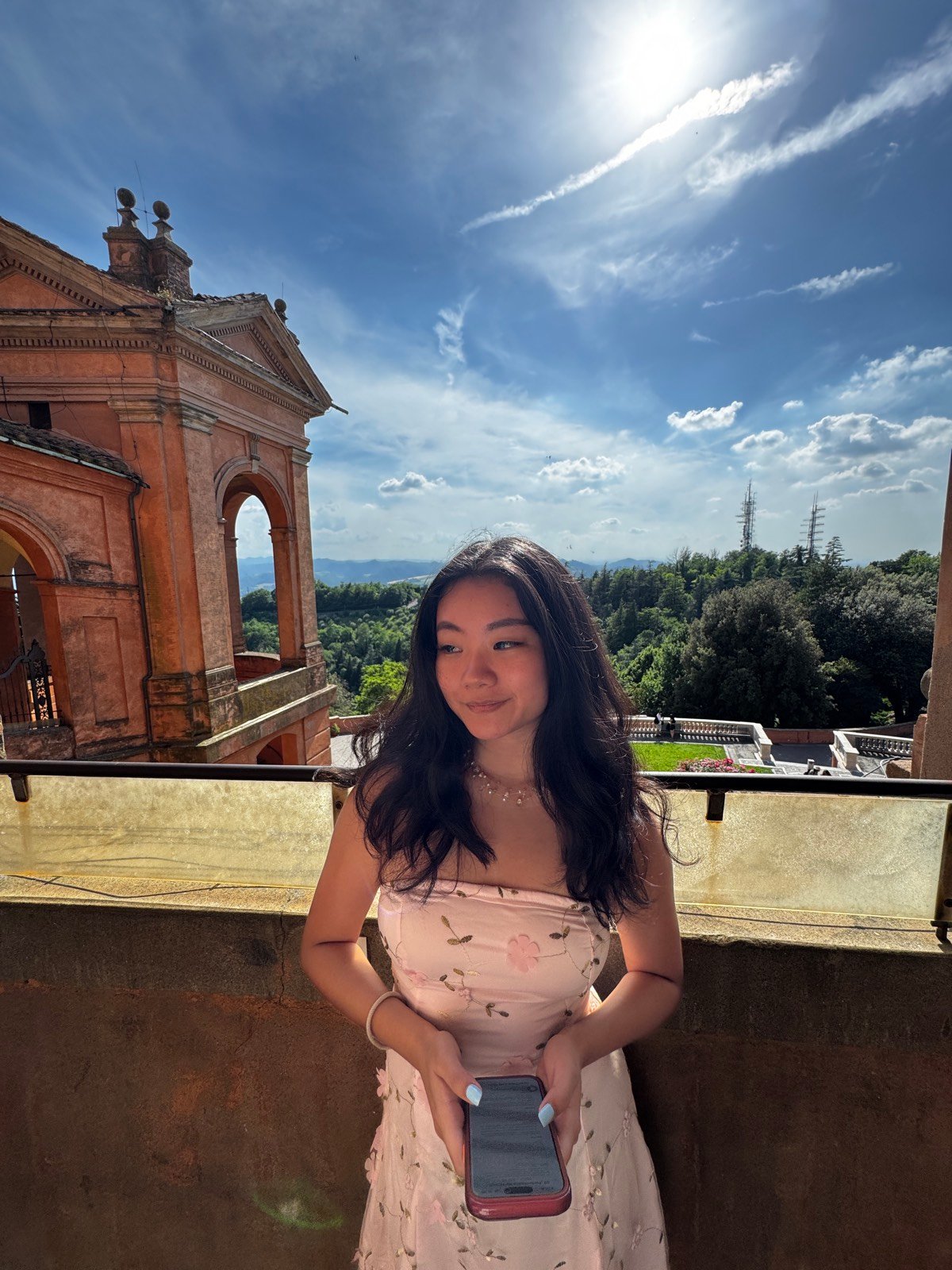 Alyssa on a balcony at San Luca with the hills around Bologna behind her