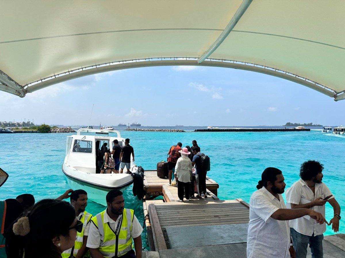 A speedboat loading passengers and luggage at the Male airport jetty