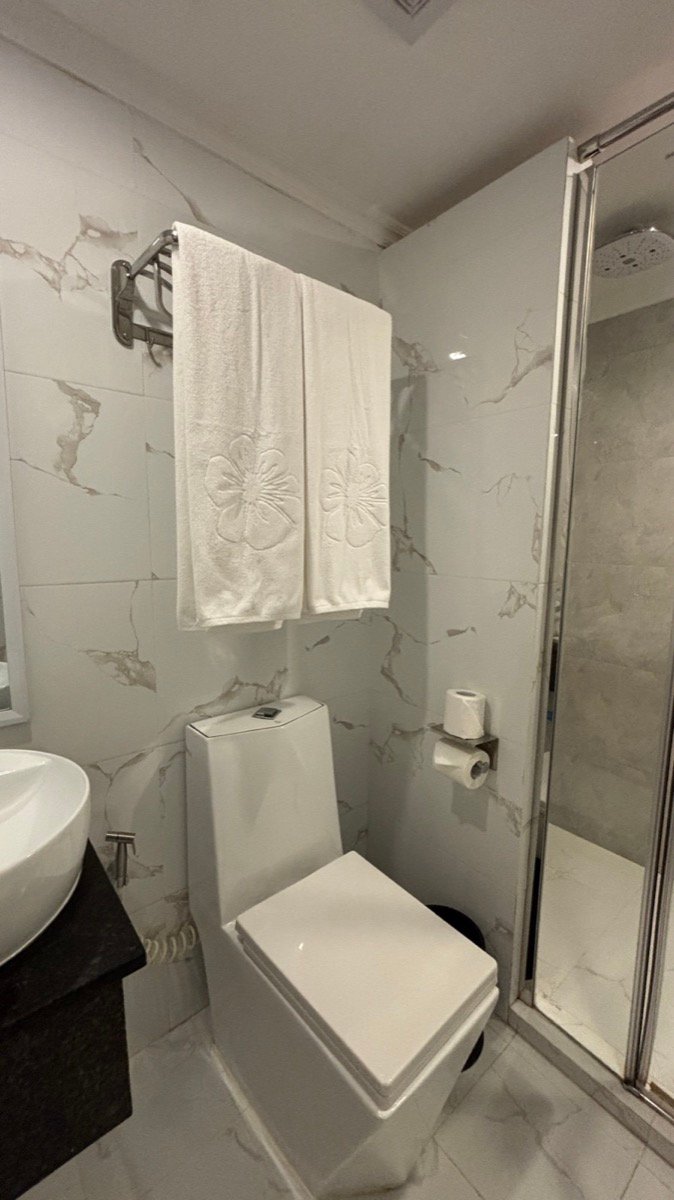 The clean marble bathroom with a walk-in shower at Kaani Palm Beach