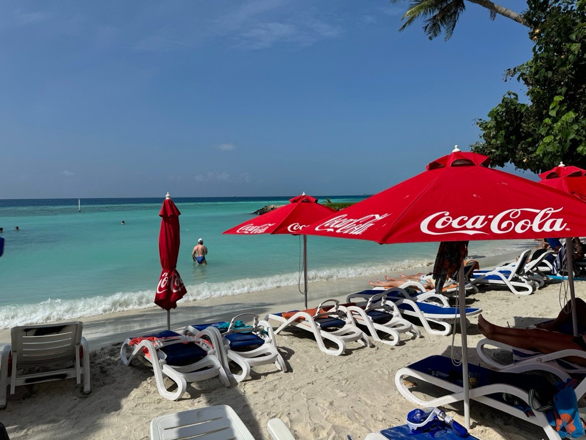 Sun loungers and red umbrellas on the bikini beach on Maafushi