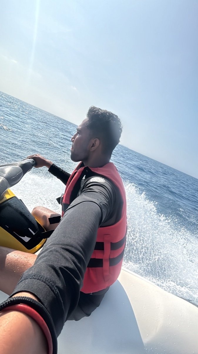 Riding a jet ski across the open sea off Maafushi