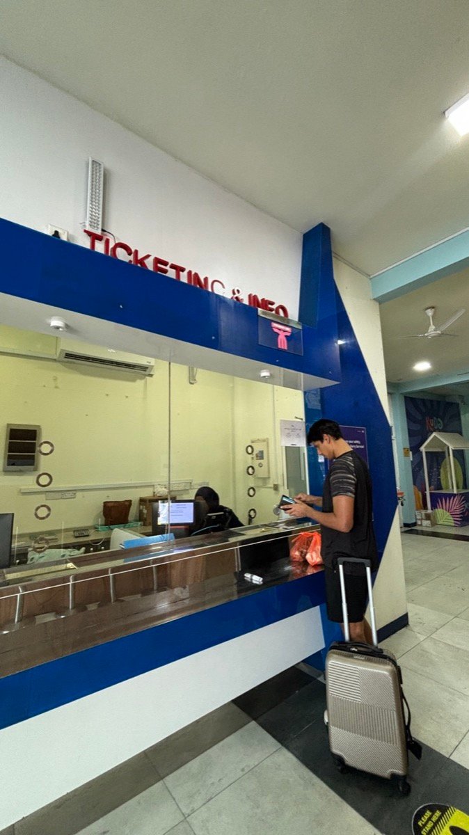 A traveller buying Male to Maafushi ferry tickets at the ticketing counter in Male