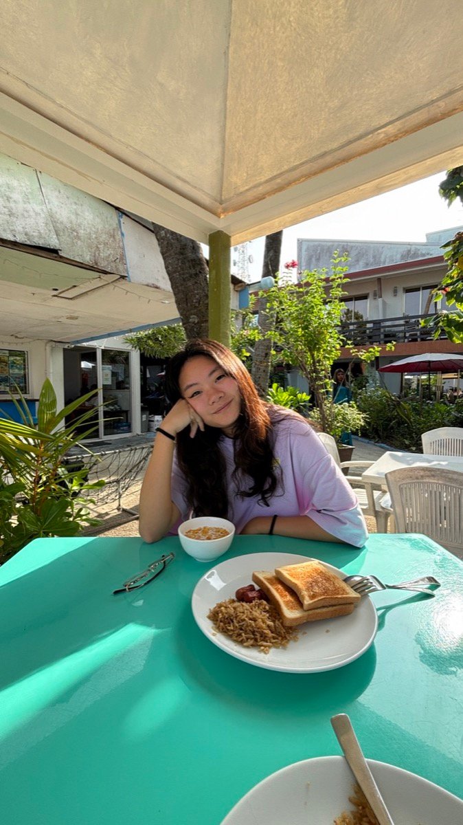 Alyssa at an outdoor table with a breakfast plate at Salmonia Seafood Restaurant on Maafushi