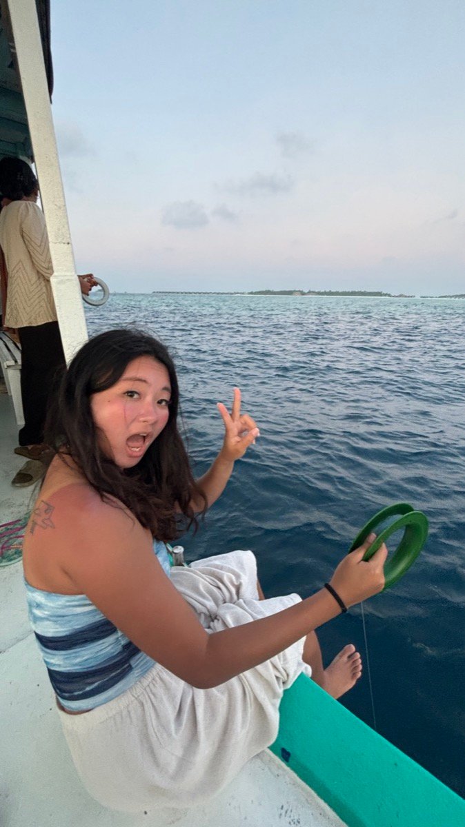 Alyssa holding a hand line off the side of the boat on a sunset fishing trip